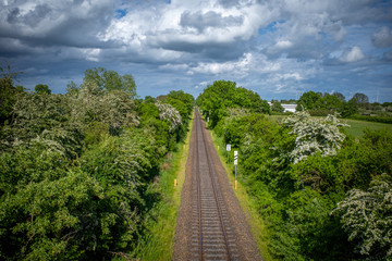 Railroad track lead straight to the horizon and the sky is blue