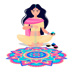 an Indian woman sits and makes rangoli from powders, chalk, marble dust, rice flour. The traditional picture of happiness on holiday Diwali