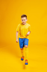 boy in soccer uniform on a yellow background