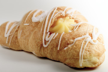 Fresh and tasty croissant with cream on light background, selective focus