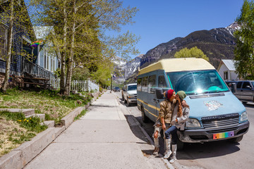 Lesbian couple kissing in front of camper van in city