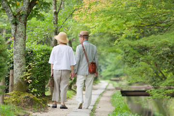 Senior couple walking along riverside footpath