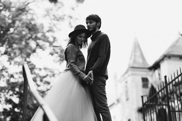 Romantic and happy caucasian couple in casual wedding clothes walking and hugging at the city streets. Love, relationships, romance, happiness, urban concept. Man and woman celebrate their marriage.