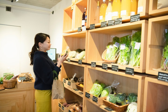 Woman shopping organic vegetable at vegetable store