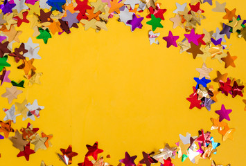 Multi-colored confetti on a yellow background with space for text.