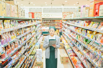 Senior woman checking restock in supermarket