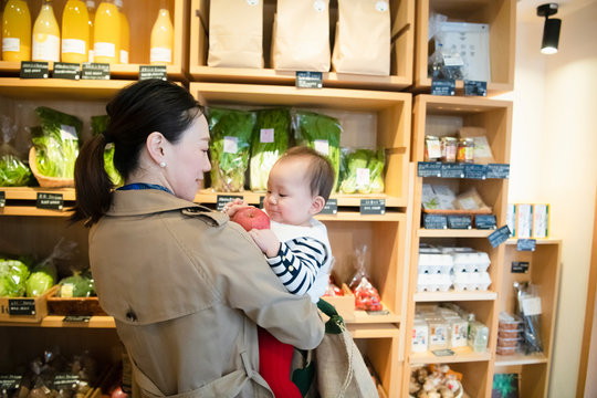 Woman shopping for organic vegetables with baby