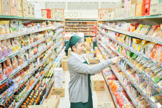 Senior woman checking restock in supermarket