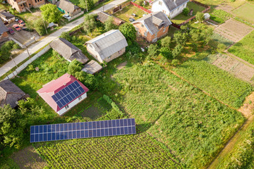 Aerial view of a house with blue solar panels for clean energy.