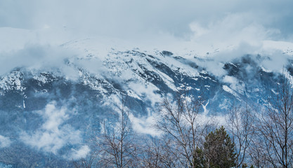Wysokie szczyty górskie pokryte gęstą mgłą © Dreamnordno