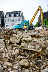 Fototapeta premium Digger demolishing houses for reconstruction