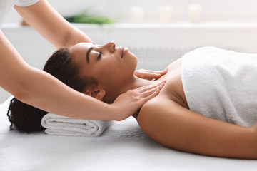 Obraz na płótnie Canvas Young black lady getting body massage at spa