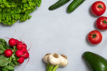 Top view of Alkaline diet foods such as tomatoes, garlic, avocado, radish, lettuce, cucumbers