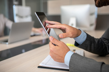 Businessman tapping and sliding on his tablet