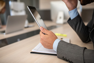 Unrecognizable businessman holding his tablet and thinking