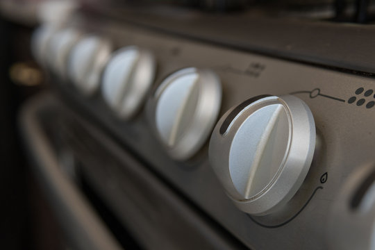 close up of stove knobs from a gray stove in a kitchen
