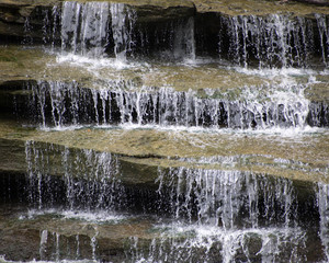 Three levels of rock ledges with waterfalls.