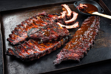 Barbecue veal spare loin ribs St Louis cut with hot honey chili marinade burnt as closeup on an old rustic metal sheet