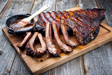 Barbecue veal spare loin ribs St Louis cut with hot honey chili marinade burnt as closeup on an old...