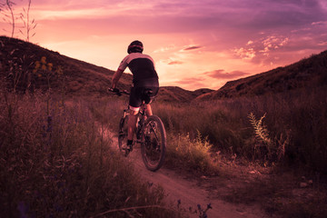hombre haciendo deporte con bicicleta de montaña al atardecer