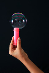 Rainbow soap bubble and red soap bubble bottle with hand