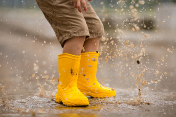 Legs in yellow boots and a puddle.