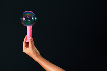 Rainbow soap bubble and red soap bubble bottle with hand