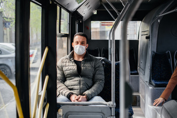 A young masked man uses public transport alone during a pandemic. Protection and prevention covid 19