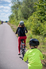 Fototapeta na wymiar Familie macht eine Fahrradtour auf einer Asphaltstraße durch die Natur
