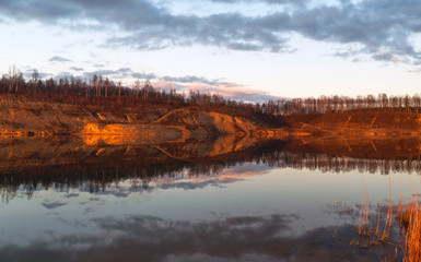 Mirror image in the lake of steep banks in spring. Vsevolozhsk. Leningrad region.
