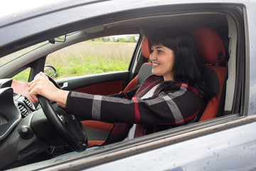 Beautiful happy woman in the car