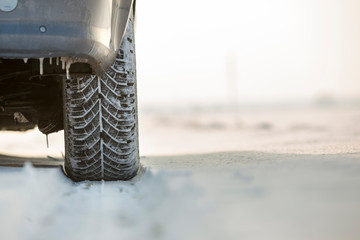 Close-up of car wheels rubber tire in deep snow. Transportation and safety concept.