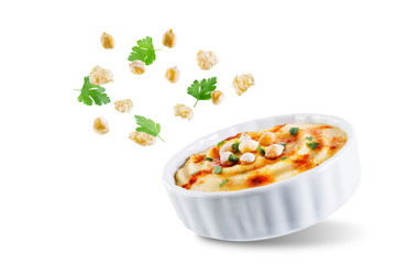 Hummus appetizer in a white bowl on a white isolated background