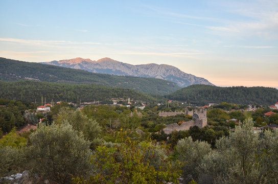 View of the ruins of the ancient Roman Kadrema castle located in the Gedelme village at sunset and mountain ridge on background. Lycian way, Turkey