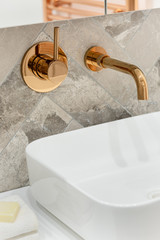 Golden tap in bathroom washbasin