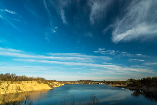 Feather clouds in the blue sky above the quarry during the day.