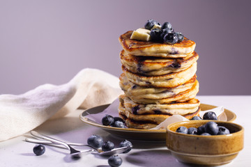 Homemade ricotta pancakes with blueberries. Lilac background.