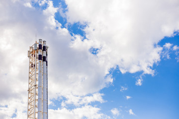 The pipe of a thermal power plant sticks out against the sky. Industrial factory construction. Electricity and heat.