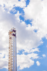 The pipe of a thermal power plant sticks out against the sky. Industrial factory construction. Electricity and heat.