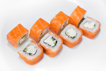 Japanese traditional roll of rice, salmon, cucumber and cream cheese on a white background
