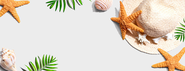 Summer concept with a straw hat and starfish overhead view - flat lay
