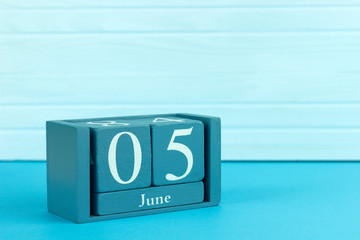 wooden calendar with the date of June 5 on a blue wooden background, International Day against...