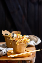 Box with noodles and quail egg on a table