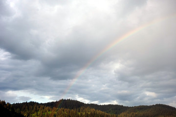 Bew&ouml;lkter Himmel nach Wetterumbruch &uuml;ber Schwarzwald mit sch&ouml;nem Regenbogen