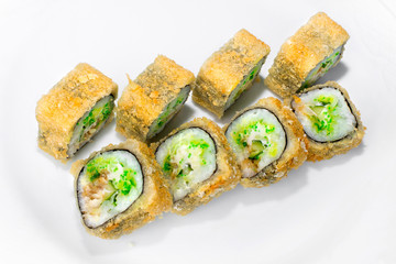 Japanese tai tempura roll made from traditional ingredients of rice, perch, cucumber, tobik, cream cheese on a white plate