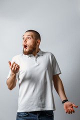 Portrait of a happy handsome young man looks away with surprise. isolated