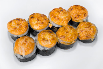 Spicy Japanese roll of rice, cream cheese, cucumber, salmon, spicy sauce and Parmesan cheese on a white plate