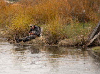 Obraz na płótnie Canvas A man fly fishing on a wild trout stream in Wyoming. 