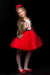 Portrait of a cute little girl on a black background. Happy chil