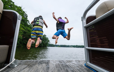 young men jumping into the lake